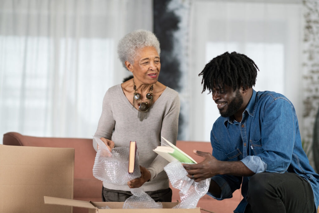 A  man helping his mother unpack a box