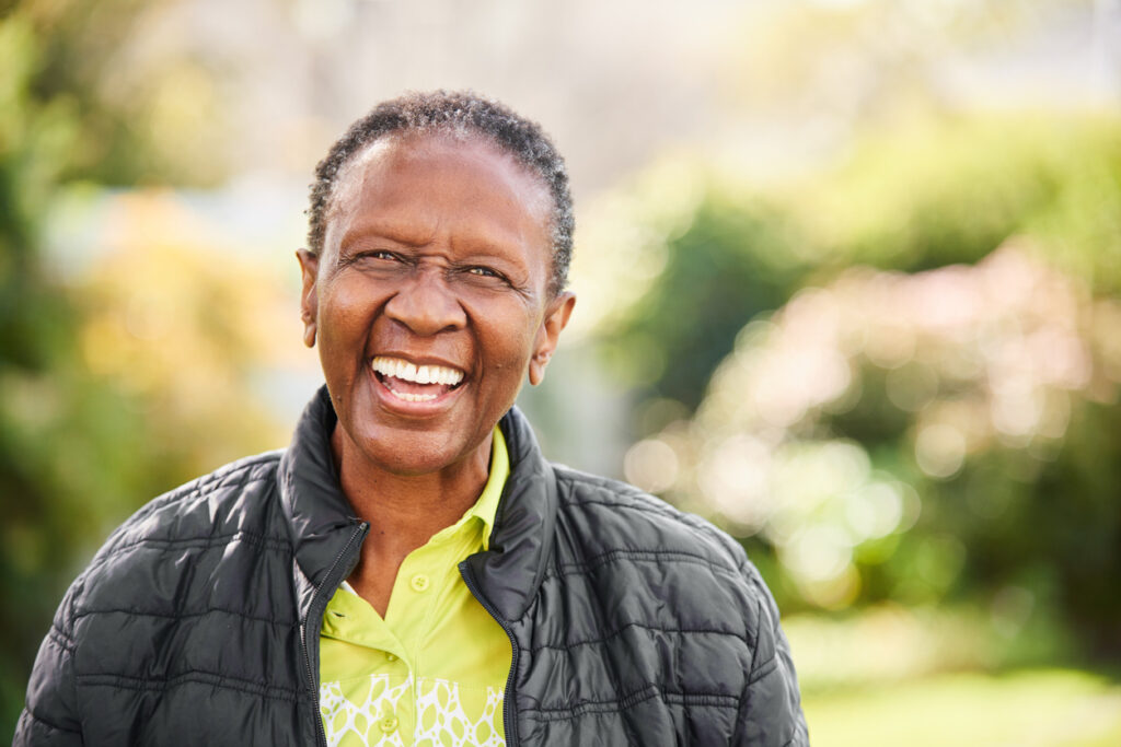 Portrait of a senior woman laughing in a black puffer jacket 