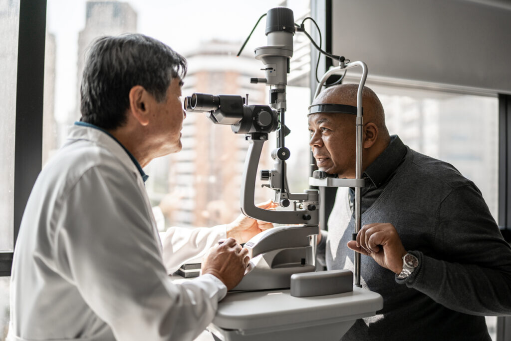 optometrist completes an eye exam for senior man who needs eyeglasses