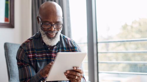 Mature black man using a digital tablet at home.